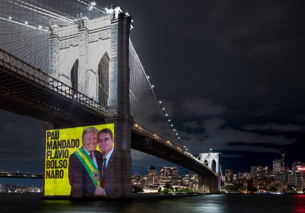Ativistas projetam em Nova York imagem de Flávio Bolsonaro entregando faixa presidencial a Trump